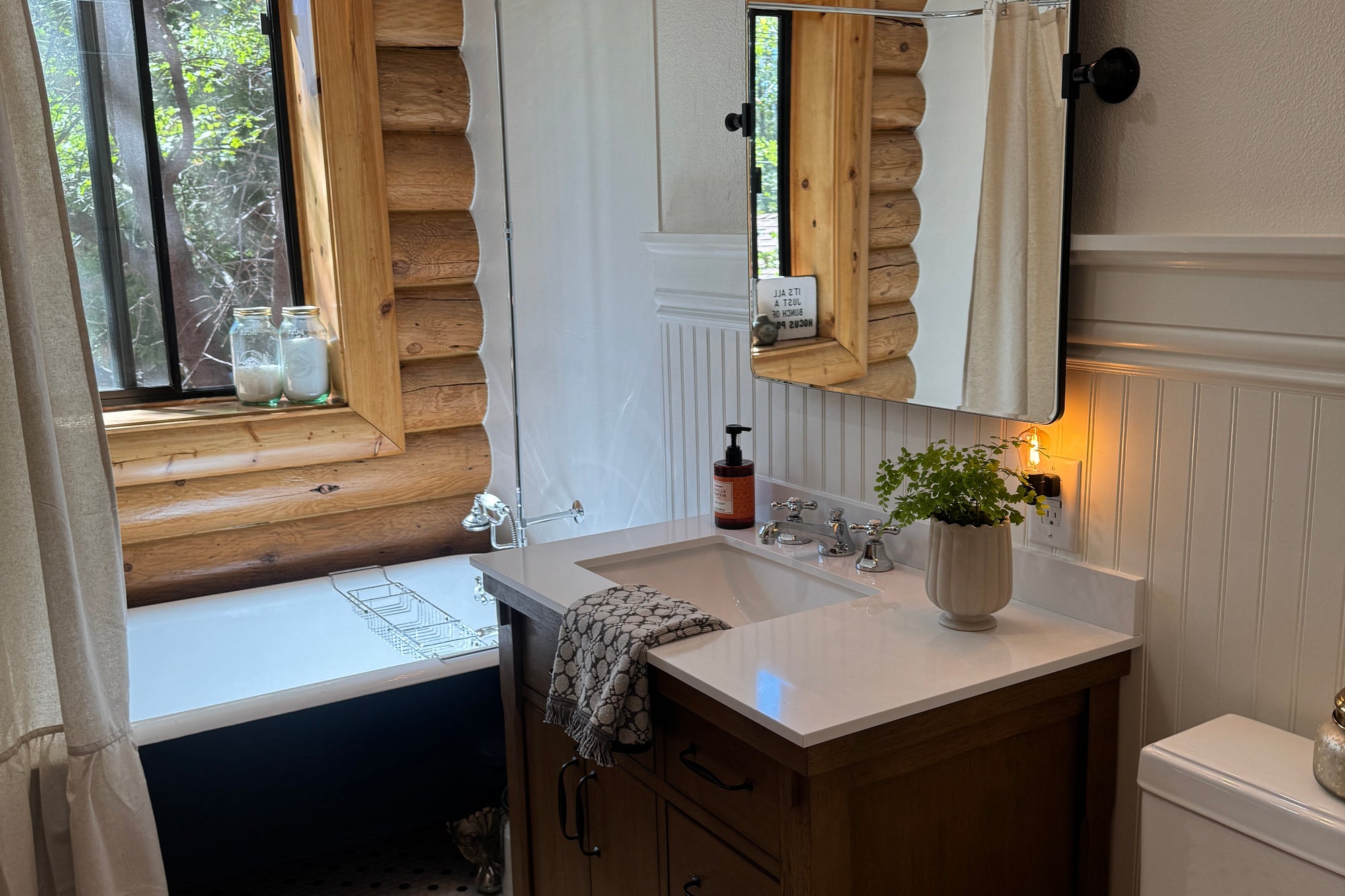 Room interior with wooden dresser, mirror, and window with wooden frame.